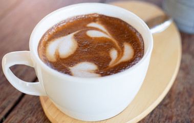 A beautiful close-up of latte coffee in cafe on a wooden table in the morning