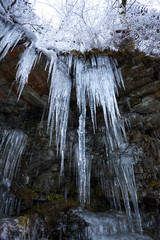 Crystal clear sharp icicles hanging down on the mountain