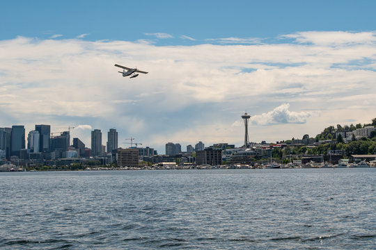 Sea Plane Flying Over Lake Union With The Seattle Skyline In The Background