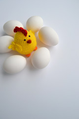 Knitted chicken and easter eggs on a white background