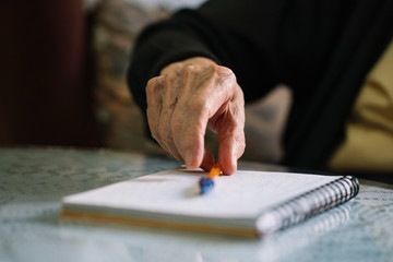 Elderly man writing in his notebook