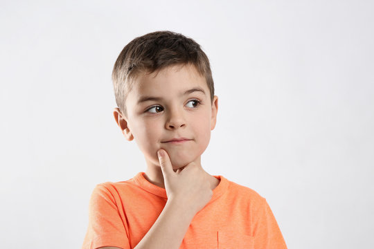 Emotional little boy in casual outfit on white background