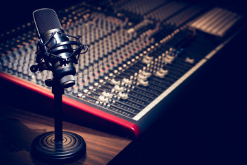 condenser microphone on audio mixing console background