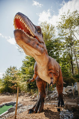 Low angle view of brown dinosaur sculpture in miniature golf course against sky © Cavan for Adobe