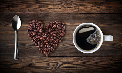 cup of coffee with beans on wooden background