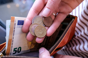girl counts euro coins in hands