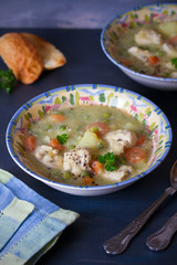 Bowl of chicken stew with vegetables on dark gray background. Vertical image