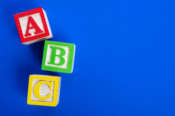 Wooden ABC blocks on blue background