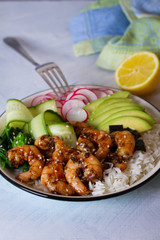 Shrimps prawns with rice, avocado, spinach, radish cucumber and  seaweed. Healthy food concept. Vertical image