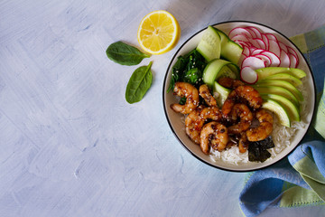 Shrimps prawns with rice, avocado, spinach, radish cucumber and  seaweed. Healthy food concept. Overhead horizontal image