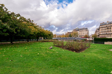 A green lawn and flower beds at Square de I’lle-de-France near Deportation Martyrs memorial, Paris, France