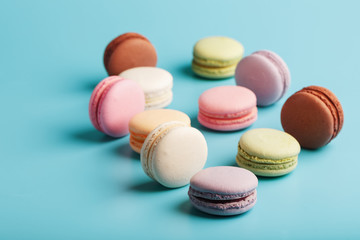 Multicolored French macaroni macaroni cookies on a blue background. Free space, top View.