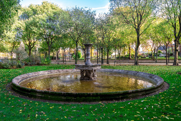 A small scenic antique fountain in the park near the Army Museum at Les Invalides complex, Paris, France