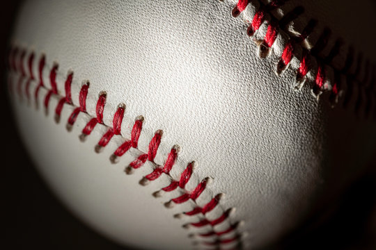A white leather baseball on a black background