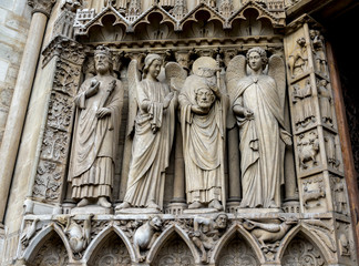 Martyr Saint Denis holding his head over the Portal of the Virgin, Notre-Dame de Paris cathedral,...