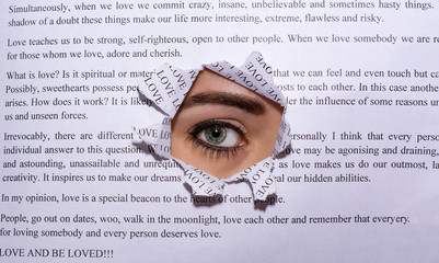 A beautiful female eye Peeps through a hole in a white leaf with a text about love