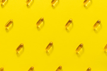 Cod lover oil omega 3 capsules on yellow background. Health care concept. 