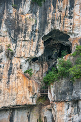 Guilin, China - May 10, 2010: Along Li River. Coseup of Large cave opening high in white, black and...