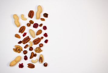 Mixed nuts and dried fruits in wooden bowl on white background, copy space