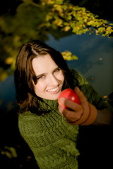 Young woman with apple enjoying autumn atmosphere