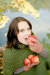 Young woman with apple enjoying autumn atmosphere