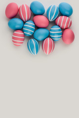 Pink and blue striped Easter eggs on a light background. Handmade fancy set of Easter eggs. Copy space, place for text. Flat lay, Top view