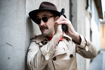 Fototapeta na wymiar Detective taking cover and aiming with his handgun