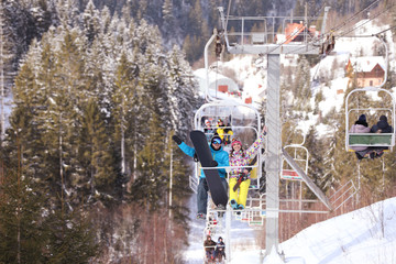 Couple using chairlift at mountain ski resort. Winter vacation