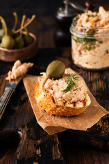 Sandwich with chicken pate with caper on a dark old board background. Selective focus