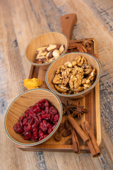 Mixed nuts and dried fruits in wooden bowl on wood background, copy space