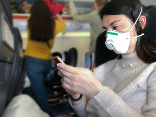 Coronavirus covid 2019 woman with respiratory mask traveling in the public transport by plain, transportation