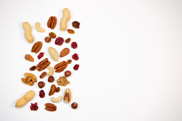 Mixed nuts and dried fruits in wooden bowl on white background, copy space