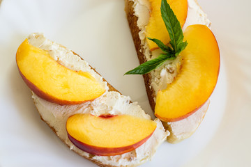 Sandwich with cream cheese, nectarine and basil. The concept of diet food. Close-up.