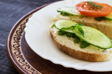 Sandwich with cream cheese, cucumber and spicy herbs. The concept of diet food. Low calorie breakfast. Close-up.