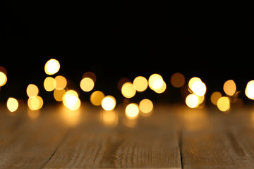 Wooden table and festive lights. Bokeh effect