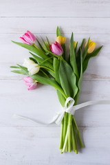 Bouquet of colorful tulips on white wooden background