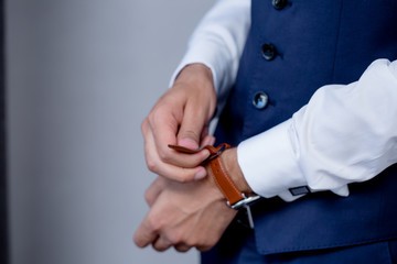 Obraz premium Businessman looking at his watch | Man hands and clock | Groom Wearing Watch