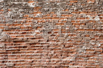Surface of the wall is made of red crumbling brick