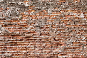 Surface of the wall is made of red crumbling brick