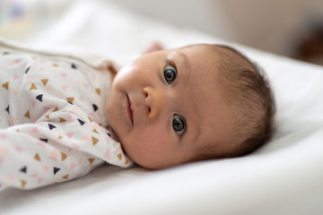 Little baby smiling joyfully on bed