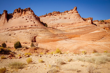 Fototapeta premium Rocks and Mountains along a trail to Tunnel Slot during sunny day with blue sky in Escalante National Monument, Grand Staircase trail, Utah, USA