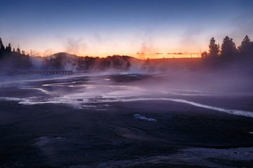 Colorful Porcelain Basin area trailwith steaming surface during beautiful sunset in Yellowstone National Park, Wyoming, USA