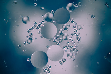 Circle oil drops on a blue water surface abstract macro background with pale gradient colors