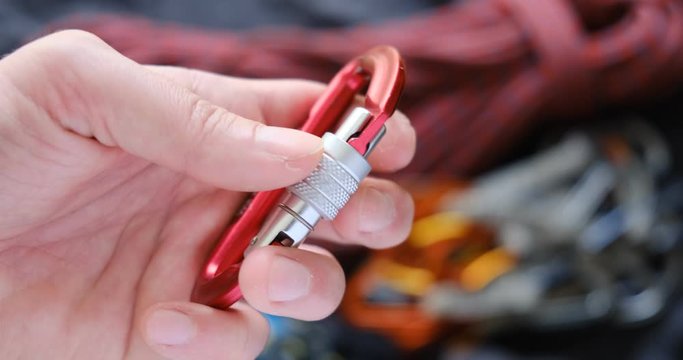 Locking a screw gate carabiner - close up. Essential sport climbing gear.