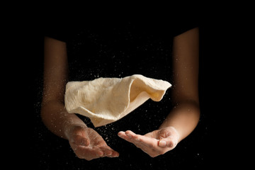 Fototapeta na wymiar Woman preparing dough for pizza on black background, closeup