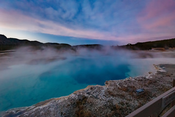 Sapphire Pool in Biscuit basin with blue steamy water and beautiful colorful sunset. Yellowstone, Wyoming, USA