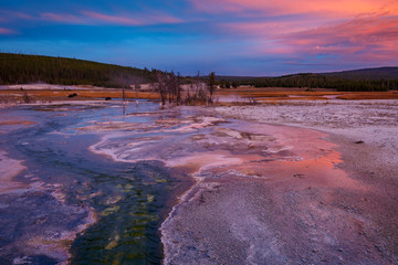 Biscuit basin with purple reflection on a steamy water and beautiful colorful sunset. Yellowstone, Wyoming, USA