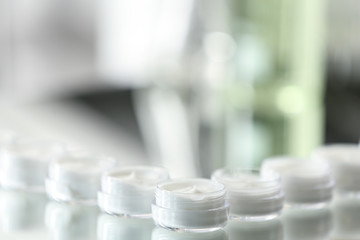 Small jars with cream in cosmetic laboratory