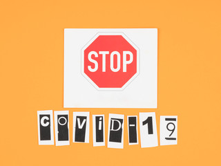 covid-19 and a stop sign on orange background.