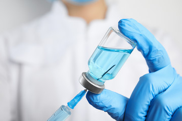 Doctor filling syringe with medication, closeup. Vaccination and immunization